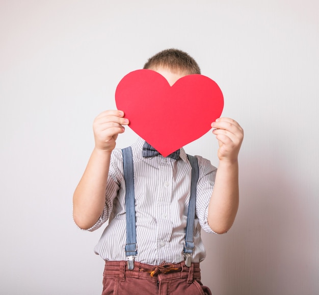 ragazzo che tiene un cuore rosso