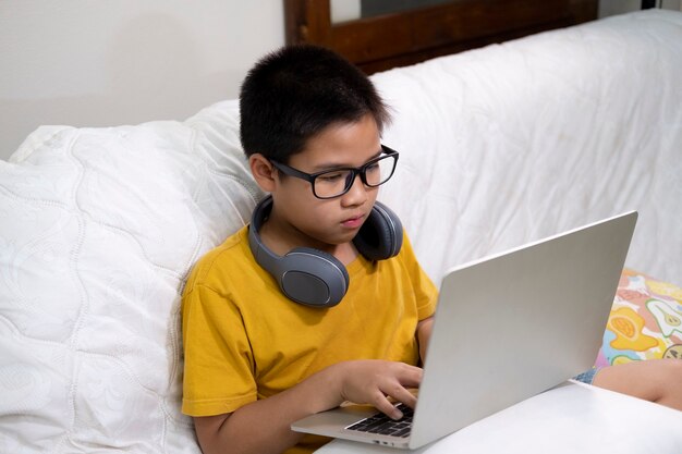 Ragazzo che utilizza computer e dispositivo mobile che studia online. Istruzione e apprendimento online.