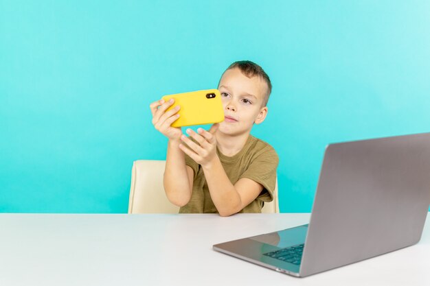 Ragazzo che utilizza il telefono per la connessione video per fare i compiti isolati.