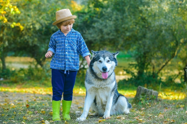 Ragazzo che viaggia lontano da casa Bambini carini con cane che cammina nel campo in una soleggiata giornata estiva Bambino turisti Ragazzino felice e cane insieme come amici come amore per il concetto di animali