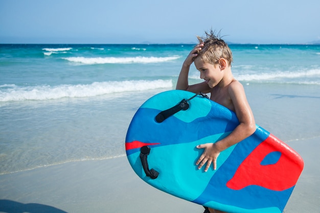 Ragazzo con bodyboard sulla spiaggia