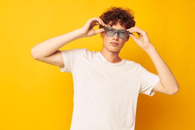 Ragazzo con capelli ricci rossi in occhiali blu maglietta bianca moda stile moderno isolato sfondo inalterato