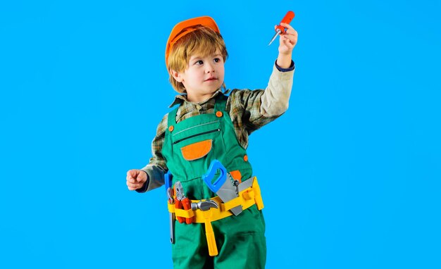 Ragazzo con casco di sicurezza e cintura per attrezzi con cacciavite gioco per bambini piccolo riparatore artigiano o