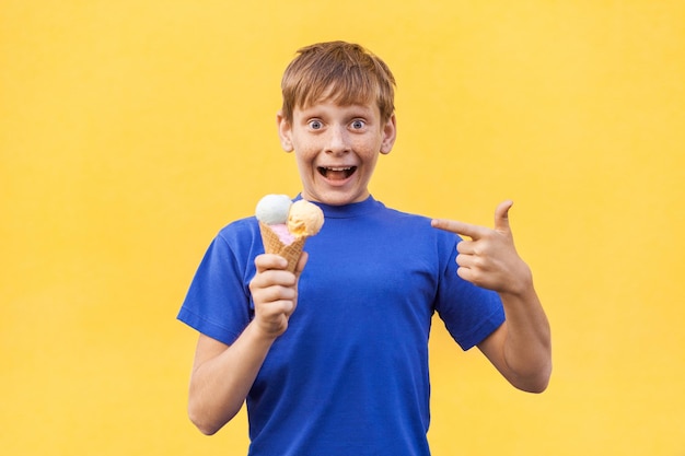 Ragazzo con gelato vicino al muro giallo