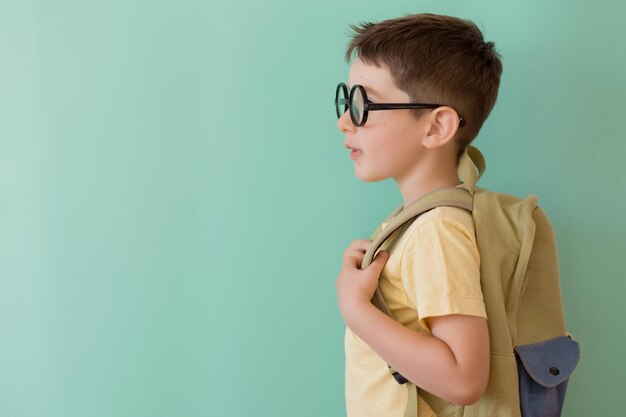 Ragazzo con gli occhiali con lo zaino della scuola