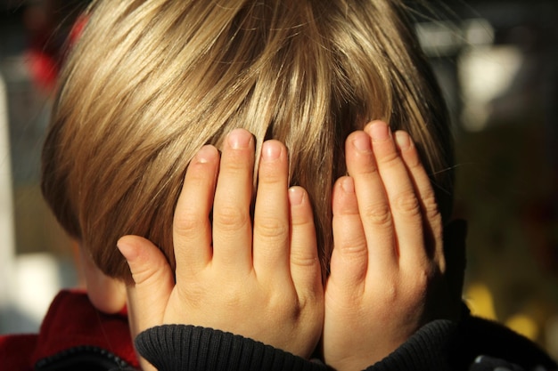 Ragazzo con i capelli biondi che gli coprono il viso