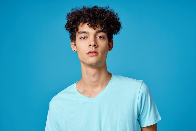 Ragazzo con i capelli ricci in tshirt blu vista ritagliata studio Foto di alta qualità