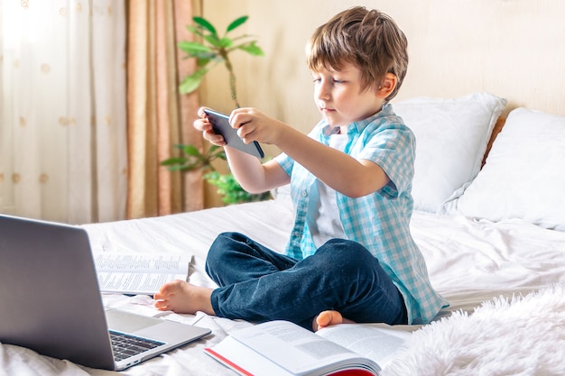 Ragazzo con il computer portatile a letto