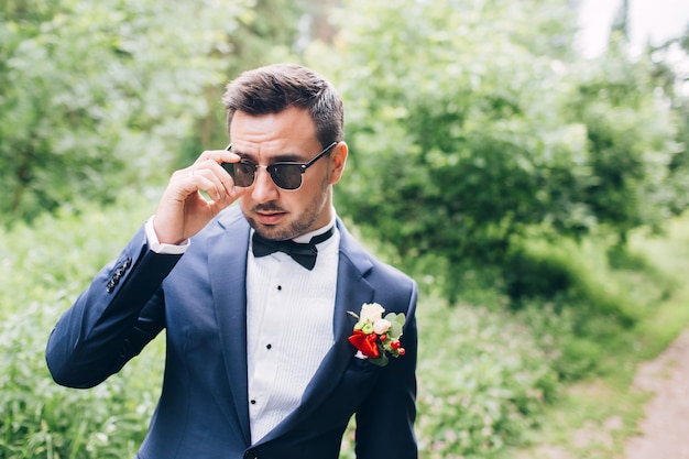 ragazzo con la barba in occhiali da sole. giovane uomo in giacca e cravatta.