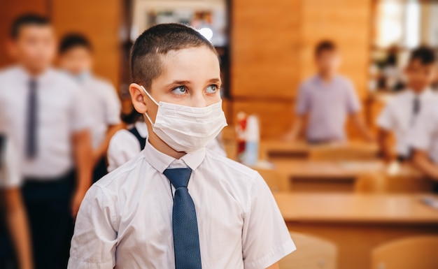 Ragazzo con maschera facciale torna a scuola dopo la quarantena e il blocco del covid-19