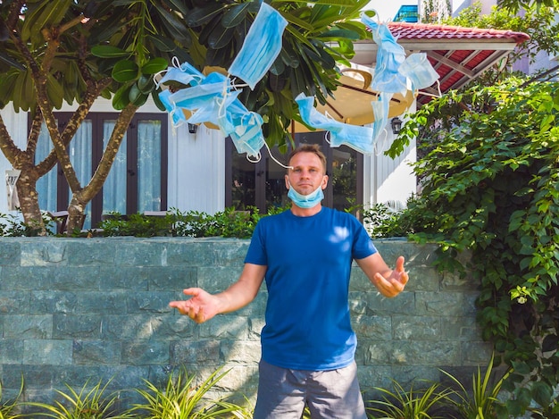 Ragazzo con maschera medica Passeggiate all'esterno nel giardino vicino alla moderna casa estiva vuole respirare maschera da buttare aspetta la fine della quarantena Isolamento Covid 19 e ricominciare la vita normale