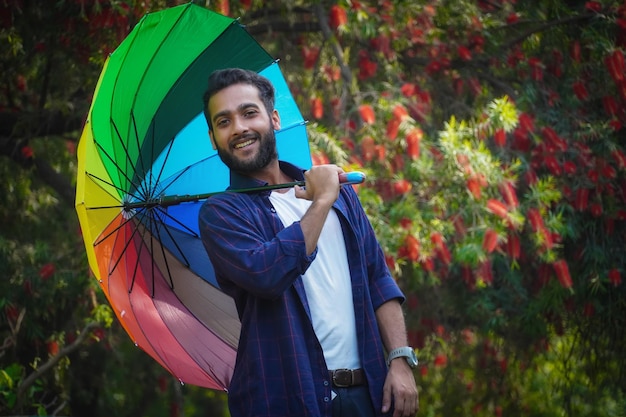 Ragazzo con ombrello colorato Felice ragazzo asiatico azienda ombrello in estate all'aperto