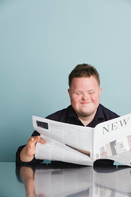 Ragazzo con sindrome di down che legge un giornale durante la pandemia di coronavirus