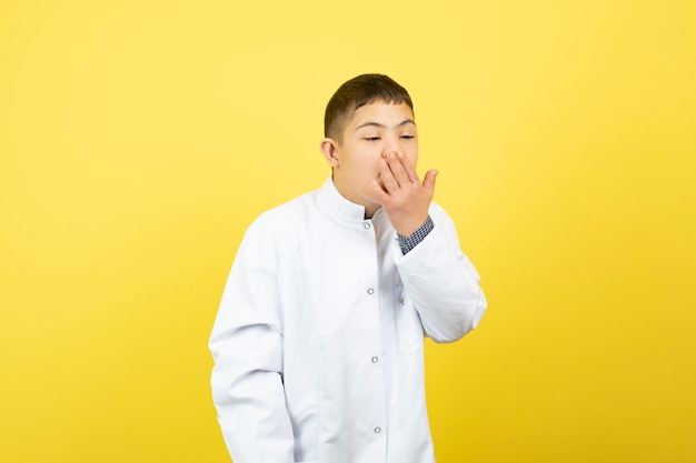 ragazzo con sindrome di down tosse sul muro giallo.