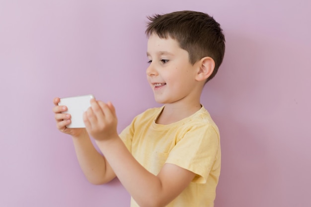 Ragazzo con smartphone su sfondo rosa