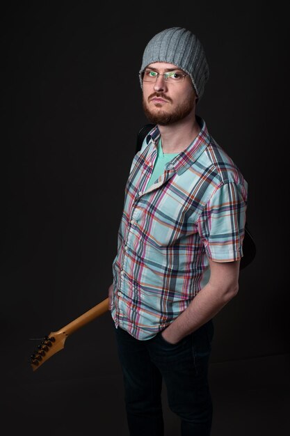 Ragazzo con una chitarra elettrica un musicista creativo in una camicia a scacchi