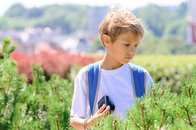 Ragazzo con una macchina fotografica digitale all'aperto in città