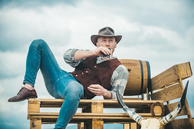 Ragazzo cowboy proprietario di un lavoratore agricolo ranch e concetto di agricoltura uomo attraente con whisky o brandy