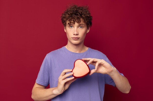 Ragazzo dai capelli rossi divertente con i capelli ricci un regalo come un cuore