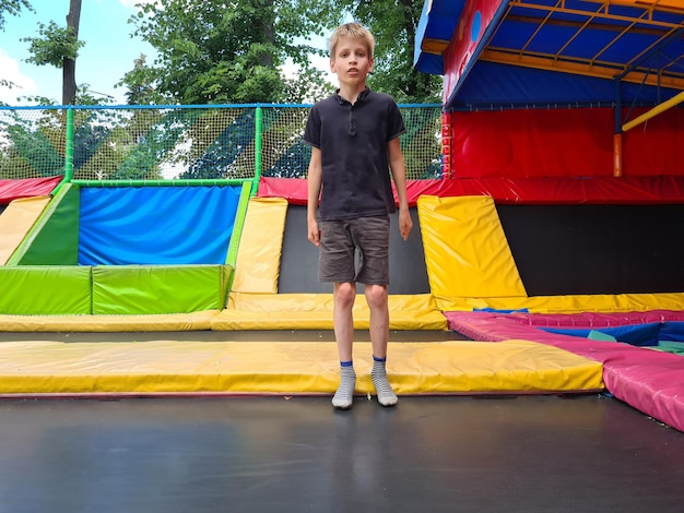 Ragazzo del bambino che salta sul trampolino nel centro di intrattenimento