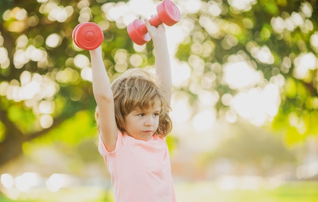 Ragazzo del bambino che si esercita nel bambino di sport di stile di vita sano dei bambini del parco con i muscoli forti