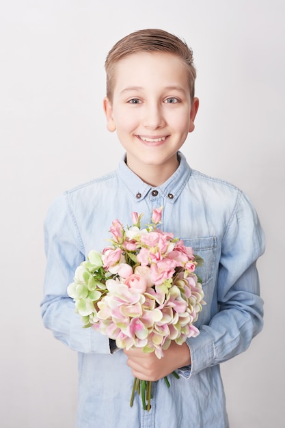 Ragazzo del bambino con il mazzo di fiori. Festa della mamma