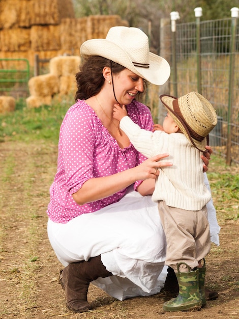 Ragazzo del bambino con sua madre in fattoria.