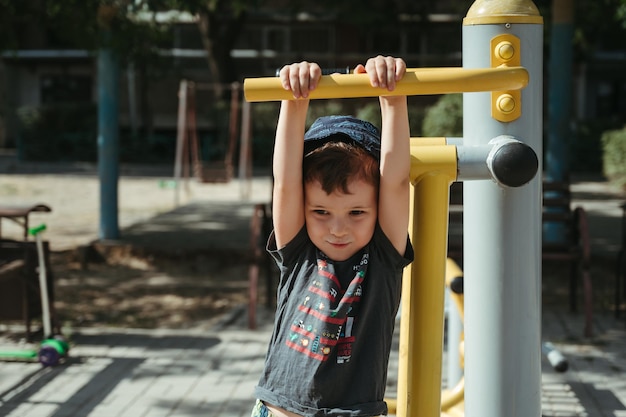 ragazzo del bambino dell'asilo che gioca con un simulatore nel parco giochi