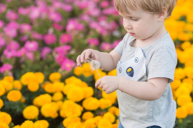 Ragazzo del bambino di sorriso felice che cammina al parco all'aperto