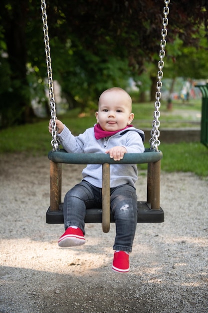 Ragazzo del bambino giovane seduto al sicuro in un parco