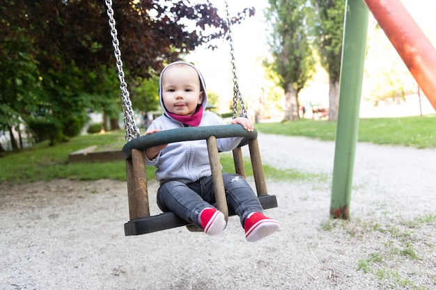 Ragazzo del bambino giovane seduto al sicuro in un parco