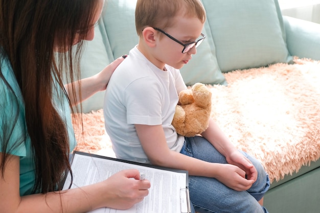 Ragazzo del bambino nell'ufficio degli psicologi. Psicologo che parla con un bambino, problemi degli studenti