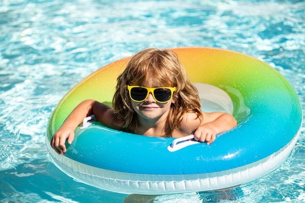 Ragazzo delle vacanze estive in piscina bambino che si diverte all'aquapark ragazzo divertente sul cir di gomma gonfiabile...