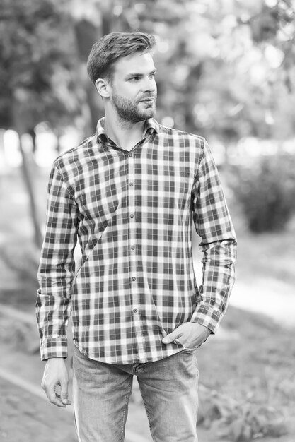 Ragazzo di bellezza e moda maschile con setole indossare camicia a scacchi concetto di barbiere stile casual moda giovane uomo con la barba lunga all'aperto Bello macho Barbuto ragazzo stile casual