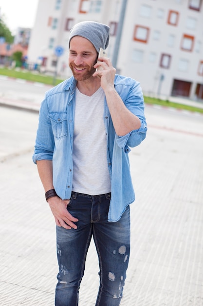 Ragazzo di moda casual che chiama con il suo cellulare