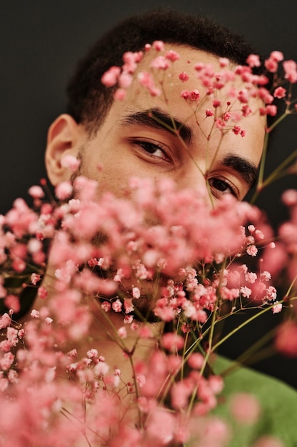 Ragazzo di razza mista in posa con fiori secchi