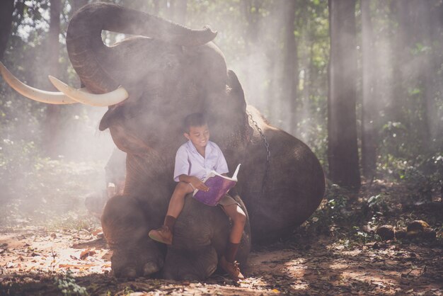 Ragazzo di scuola che gioca nella giungla con il suo amico elefante