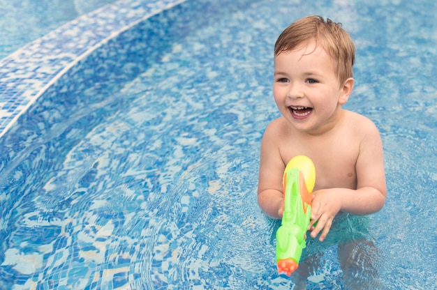 Ragazzo di smiley con pistola ad acqua