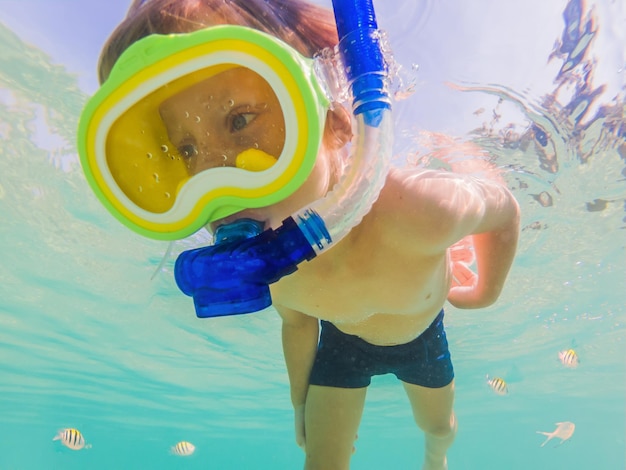 Ragazzo di studio della natura subacquea che fa snorkeling nel mare azzurro