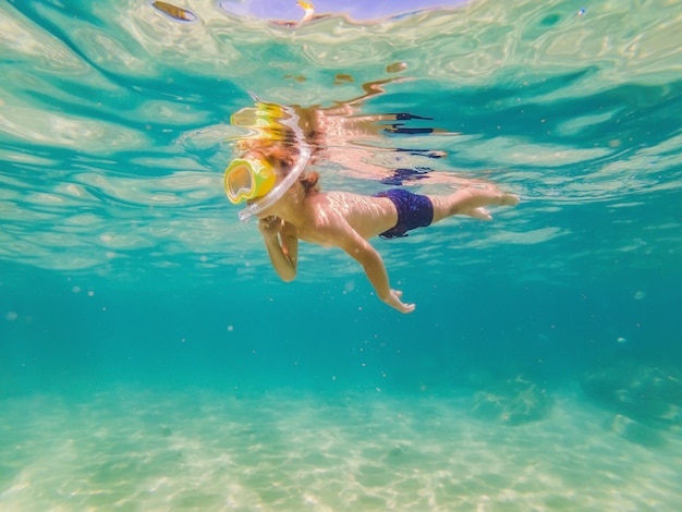 Ragazzo di studio della natura subacquea che fa snorkeling nel mare azzurro