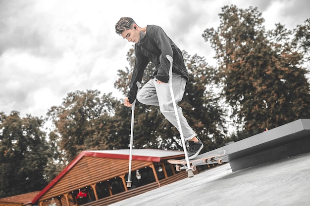 Ragazzo disabile che salta con successo sullo skateboard dal trampolino di lancio