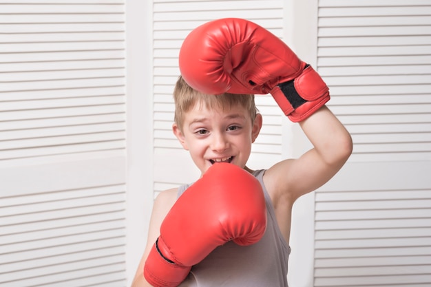 Ragazzo divertente in guantoni da boxe rossi. Sport