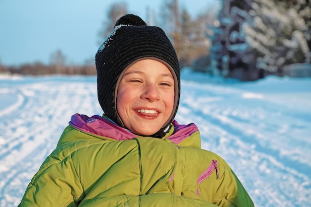 Ragazzo divertente in una soleggiata giornata invernale che ride per strada