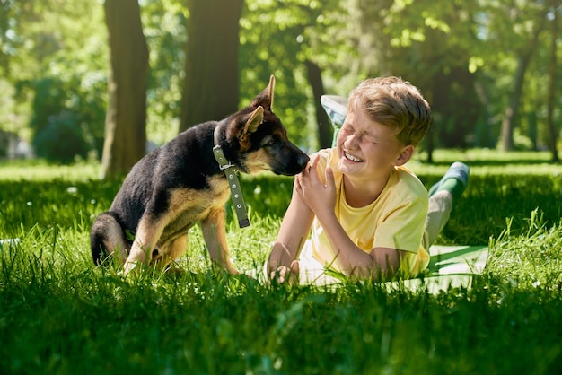 Ragazzo e cucciolo che camminano e giocano al parco estivo