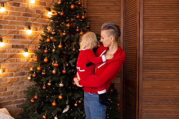 Ragazzo e madre in una stanza decorata a festa per Natale