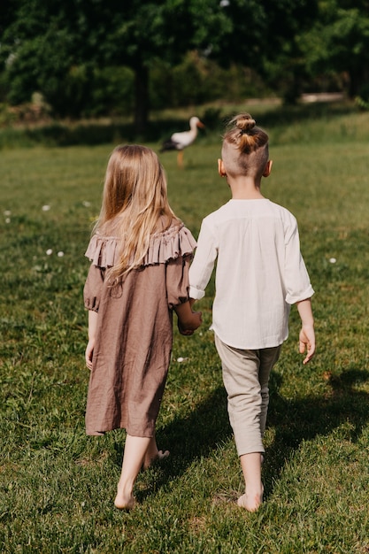 Ragazzo e ragazza che camminano sull'erba verde, a piedi nudi