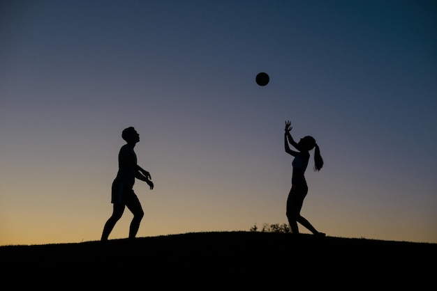 Ragazzo e ragazza che giocano a pallavolo nel fine settimana.