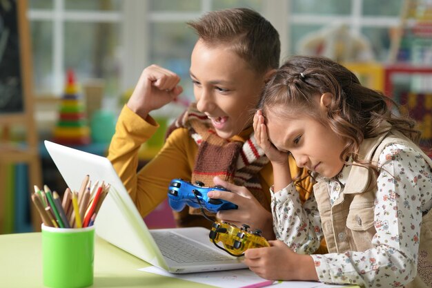 Ragazzo e ragazza che giocano al videogioco sul computer portatile