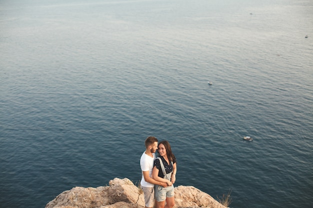 Ragazzo e ragazza che si siedono su una roccia