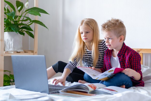 ragazzo e ragazza che studiano a casa con il portatile, facendo i compiti a scuola